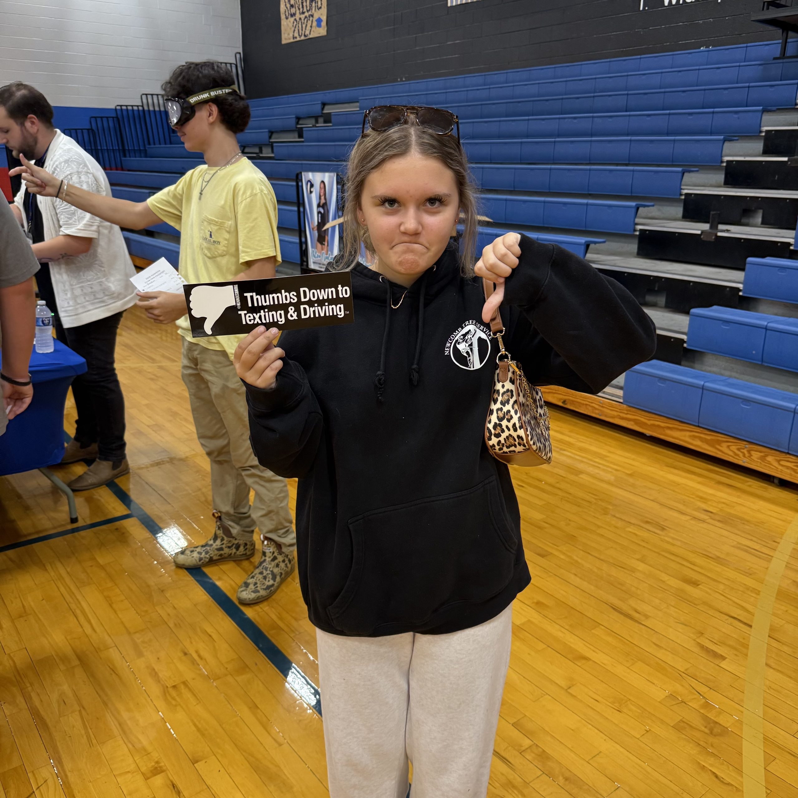 Student gives a thumbs down to texting and driving in a gym
