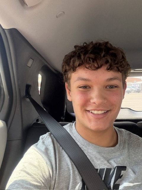 Student buckled in for a seat belt selfie